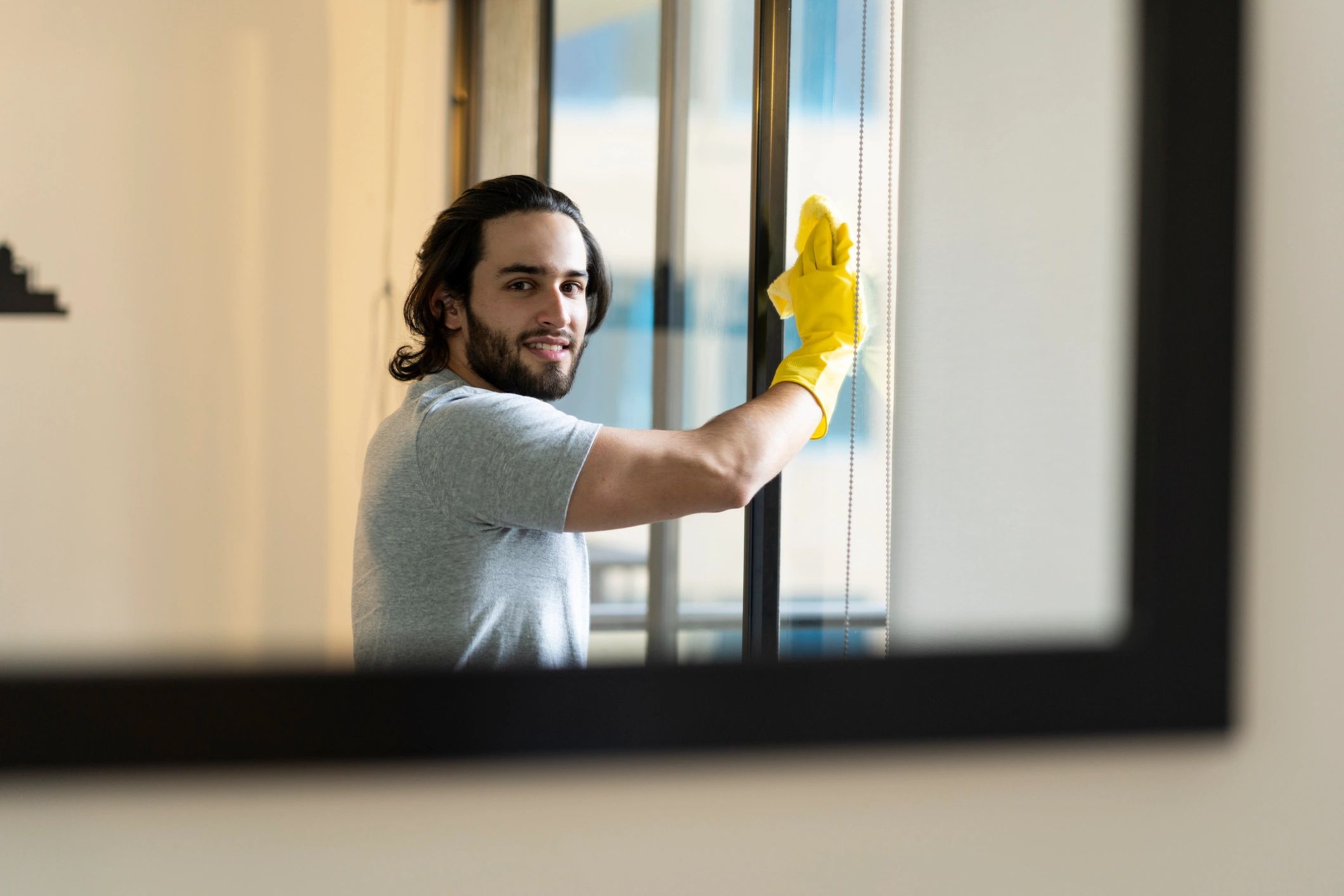 Man cleaning the window of his house