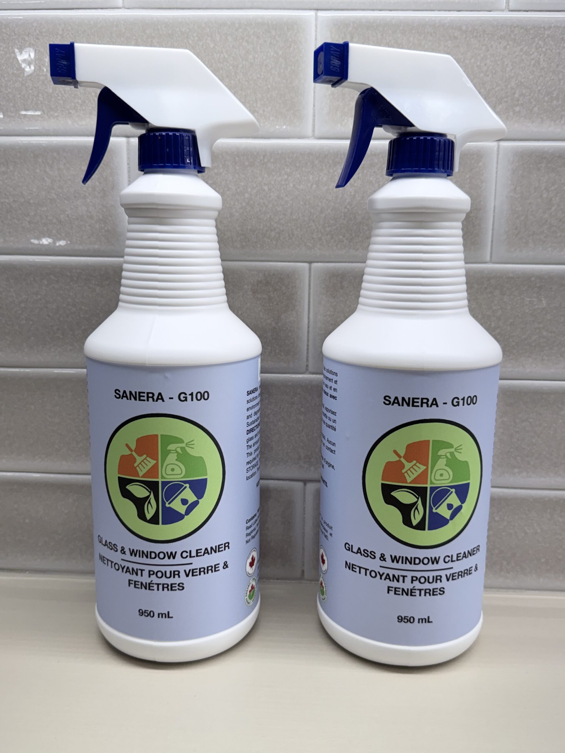 Two spray bottles of a glass cleaning product called Sanera G100